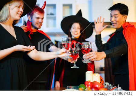 Halloween party react with surprise and laughter to spooky props like pumpkins and a ghost skeleton. Perfect seasonal fun, decor, and festive vibes. 134967433