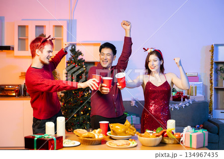 Friends celebrate Christmas with gift exchanges, festive food, and perfect scene for holiday and New Year themes filled with joy and togetherness 134967435