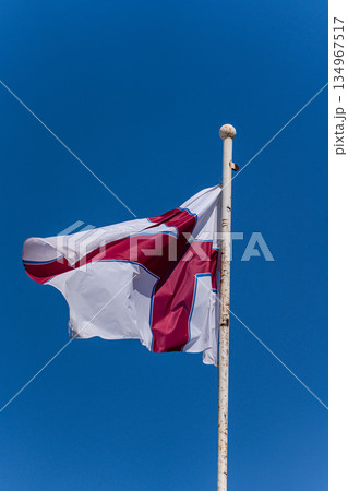 Georgian flag on the clear blue sky background Georgian flag on the clear blue sky background 134967517