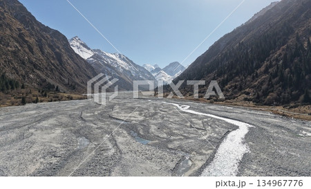 Majestic mountain landscape with riverbed and snow-capped peaks 134967776
