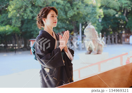 神社の神殿に参拝する振袖姿の女性|祈り・伝統・日本文化 神社の神殿に参拝する振袖姿の女性|祈り・伝統・日本文化 134969321