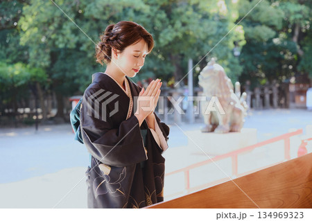 神社の神殿に参拝する振袖姿の女性|祈り・伝統・日本文化 神社の神殿に参拝する振袖姿の女性|祈り・伝統・日本文化 134969323
