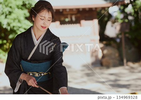 神社の手水舎で手を清める振袖姿の女性|参拝・着物・伝統美 134969328