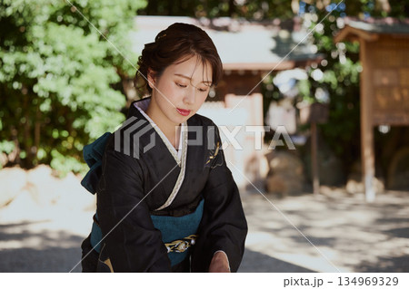神社の手水舎で手を清める振袖姿の女性|参拝・着物・伝統美 134969329
