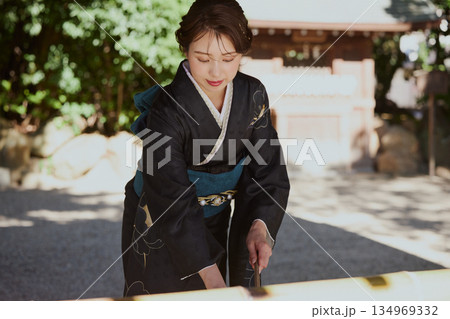 神社の手水舎で手を清める振袖姿の女性|参拝・着物・伝統美 134969332