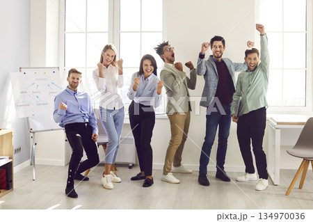 Happy business team celebrating success and having fun during a work meeting in the office Happy business team celebrating success and having fun during a work meeting in the office 134970036