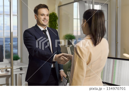 Business handshake between businessman and woman in modern office after hiring 134970701