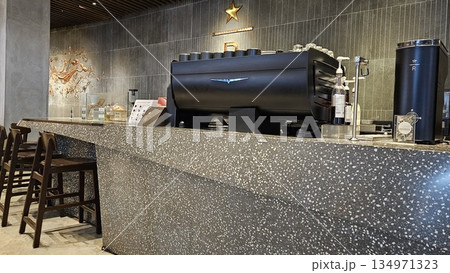 A sleek Starbucks Reserve counter with espresso machines, and holiday merchandise blends premium coffee culture A sleek Starbucks Reserve counter with espresso machines, and holiday merchandise blends premium coffee culture 134971323