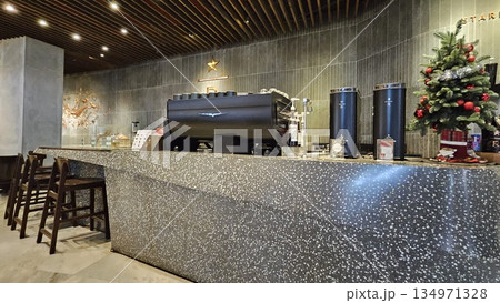 A sleek Starbucks Reserve counter with espresso machines, and holiday merchandise blends premium coffee culture A sleek Starbucks Reserve counter with espresso machines, and holiday merchandise blends premium coffee culture 134971328