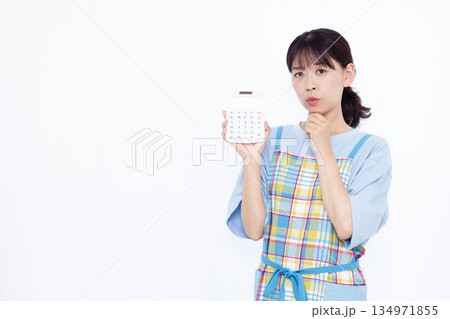 電卓をもって悩んでいる主婦 電卓をもって悩んでいる主婦 134971855