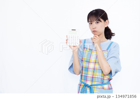 電卓をもって悩んでいる主婦 134971856