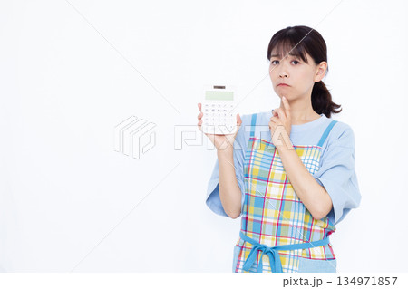 電卓をもって悩んでいる主婦 134971857