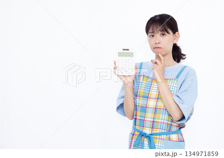 電卓をもって悩んでいる主婦 電卓をもって悩んでいる主婦 134971859