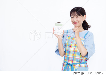 電卓をもって悩んでいる主婦 134972047
