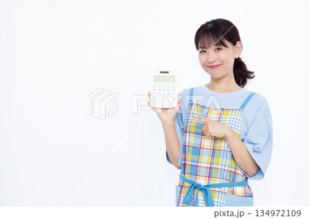 笑顔で電卓を指さしている主婦 134972109