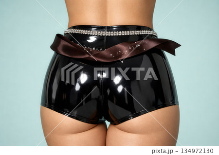 High Waist Shiny Black Latex Shorts With Diamond Belt And Brown Silk Ribbon On Blue Background 134972130