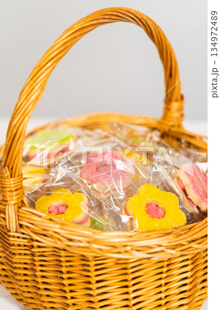 Close-up of a yellow flower-shaped Easter Cookie Sandwich with Raspberry Buttercream in clear wrap, nestled in a rustic basket. A vibrant and cheerful springtime dessert presentation. Close-up of a yellow flower-shaped Easter Cookie Sandwich with Raspberry Buttercream in clear wrap, nestled in a rustic basket. A vibrant and cheerful springtime dessert presentation. 134972489