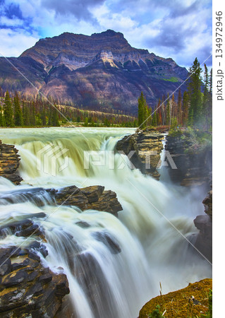 Athabasca Falls Waterfall Flowing Over Rocky Cliffs With Majestic Mountain In Background 134972946