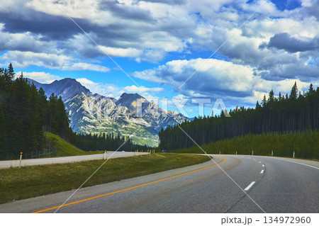 Mountain Highway Through Forest And Dramatic Sky In Canadian Rockies 134972960