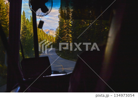 Bus Interior Winding Road and Mountain Forest Landscape at Sunset 134973054