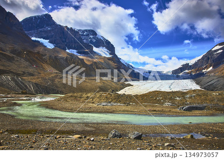 Athabasca Glacier Meltwater Stream and Rugged Mountain Peaks in Jasper Canada 134973057
