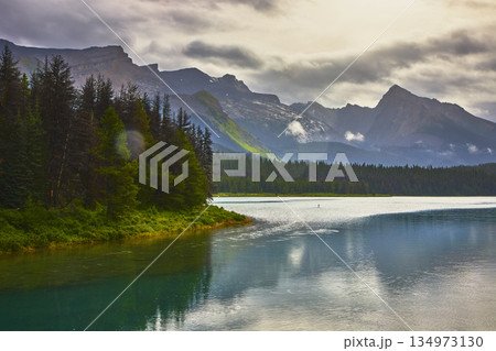 Maligne Lake Calm Water Evergreen Forest and Majestic Mountain Range Reflection 134973130