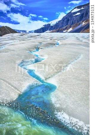 Glacial Meltwater Streams Flowing Across Athabasca Glacier with Majestic Mountain Scenery Glacial Meltwater Streams Flowing Across Athabasca Glacier with Majestic Mountain Scenery 134973131