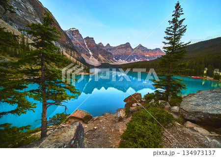 Lake Moraine Sunrise Reflection with Blue Water Pine Trees and Mountain Peaks Lake Moraine Sunrise Reflection with Blue Water Pine Trees and Mountain Peaks 134973137