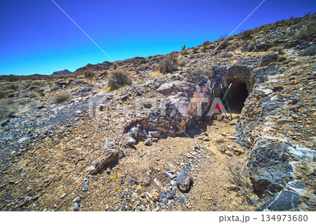 Abandoned Mine Entrance Desert Landscape and Rocky Terrain in Harsh Sunlight 134973680