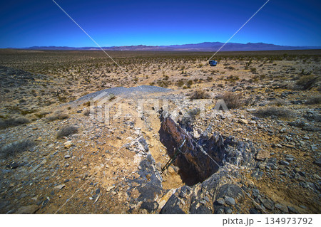 Abandoned Mine Shaft and Desert Landscape in Nevada with Isolated Vehicle Abandoned Mine Shaft and Desert Landscape in Nevada with Isolated Vehicle 134973792