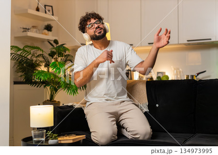 Arabian man plays air guitar dances rock n roll seated laughs energy fun music night indoors excited Arabian man plays air guitar dances rock n roll seated laughs energy fun music night indoors excited 134973995