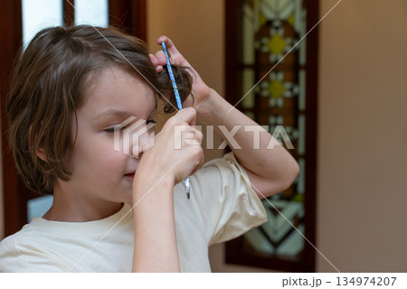 Young boy combing his brown hair. Child's morning grooming routine and self-care concept Young boy combing his brown hair. Child's morning grooming routine and self-care concept 134974207