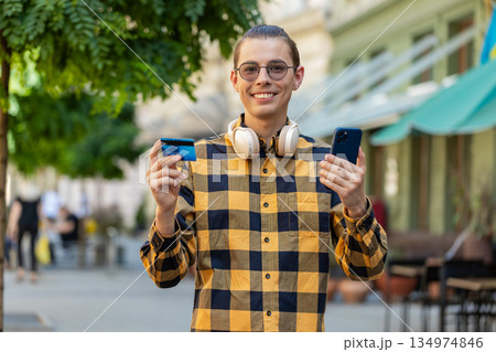 Man using credit bank card smartphone while transferring money, purchases online shopping outdoors 134974846