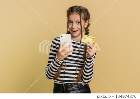 Child girl use credit bank card smartphone while transferring spend money purchases online shopping 134974876