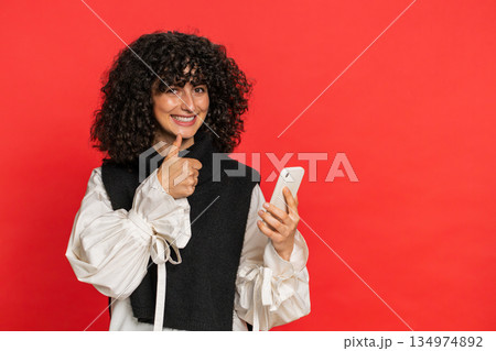 Woman using smartphone showing pointing on phone, advertising web application, positive feedback Woman using smartphone showing pointing on phone, advertising web application, positive feedback 134974892
