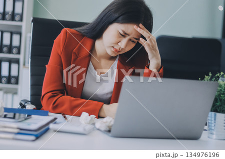 tired business woman sleepy and bored from sitting at a desk for a long time and has office syndrome 134976196