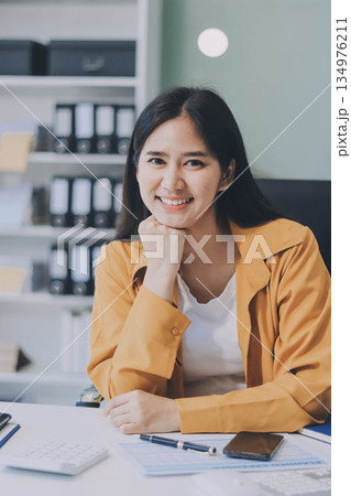 Business woman using calculator for do math finance on wooden desk in office and business working background, tax, accounting, statistics and analytic research concept. 134976211