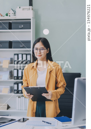 Business woman using calculator for do math finance on wooden desk in office and business working background, tax, accounting, statistics and analytic research concept. 134976221