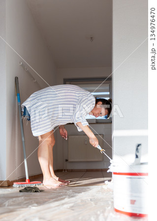 Scenic view happy young adult happy smiling woman portrait painting wall roller for moving in new house residential apartment with family. Casual lifestyle scene female person decorate living space Scenic view happy young adult happy smiling woman portrait painting wall roller for moving in new house residential apartment with family. Casual lifestyle scene female person decorate living space 134976470