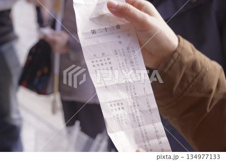 神社のおみくじで運勢を占う女性の手元 神社のおみくじで運勢を占う女性の手元 134977133