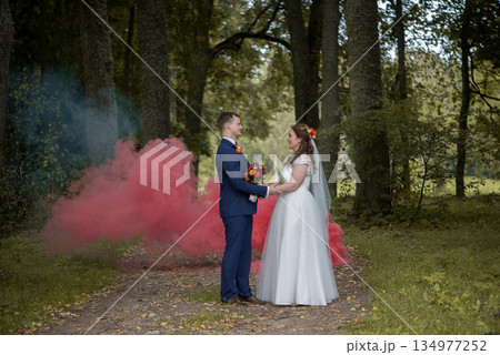 Bride And Groom Holding Bouquet Between Them 134977252