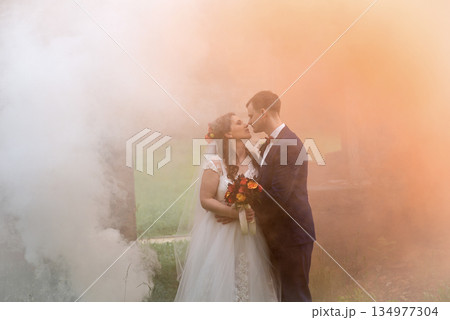 Young Wedding Couple Kissing In Dense Smoke Young Wedding Couple Kissing In Dense Smoke 134977304