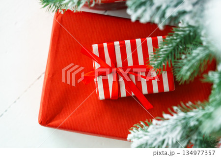 Red wrapped gift boxes, presents under festive Christmas tree with lights and holiday decorations Red wrapped gift boxes, presents under festive Christmas tree with lights and holiday decorations 134977357