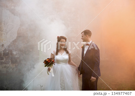 Young Groom Looking At Bride In Smoke Young Groom Looking At Bride In Smoke 134977407