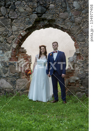 Young Wedding Couple Framed By Stone Arch Young Wedding Couple Framed By Stone Arch 134977408