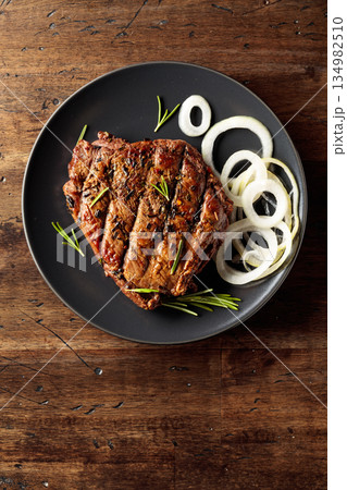 Grilled ribeye beef steak with rosemary and marinated onion. Grilled ribeye beef steak with rosemary and marinated onion. 134982510