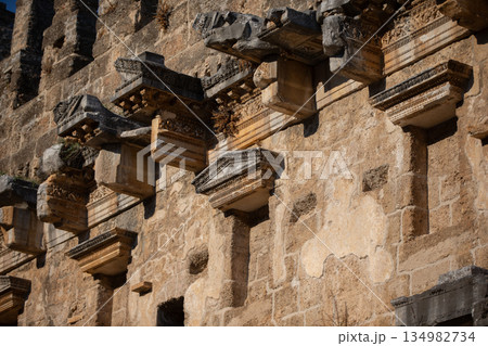 Part of the stone wall of the ancient amphitheater with architectural elements. 134982734