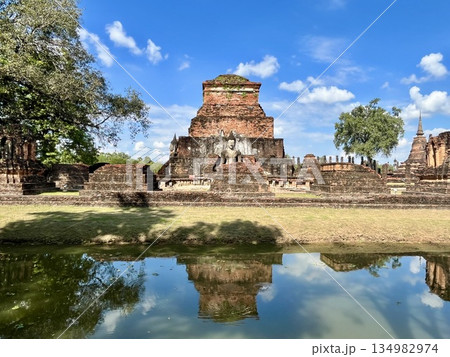 水辺に反射するスコータイ歴史公園内のワット・マハタート遺跡と石像 134982974
