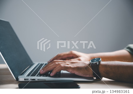 Close-up of hands typing on laptop keyboard with a watch on the wrist. . Close-up of hands typing on laptop keyboard with a watch on the wrist. . 134983161