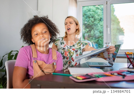 Stressed mother struggling with unmotivated child doing homework 134984701